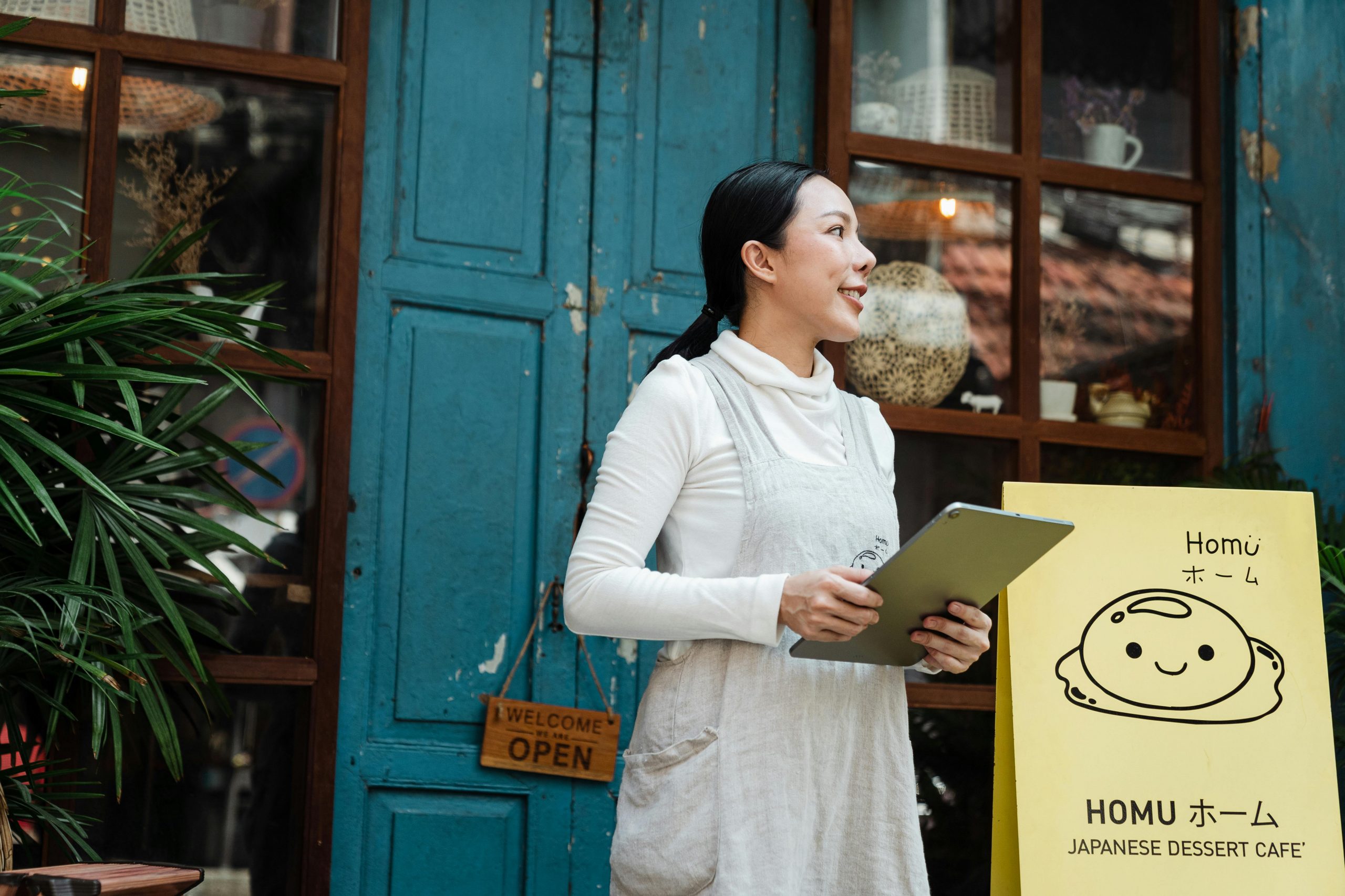 bakery owner standing next to traditional advertising signage